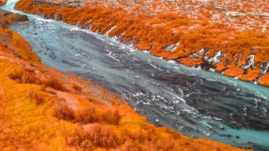 Batı İzlanda 'daki Barnafoss şelalelerinde güzel mavi nehir ve kaya oluşumlarının hava manzarası..