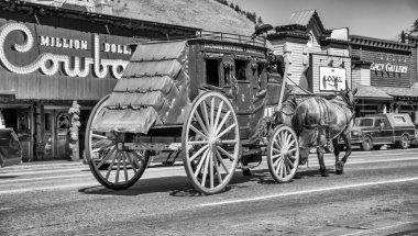 Jackson Hole, WY - 12 Temmuz 2019: Güneşli bir yaz gününde şehir sokaklarında renkli bir at arabası.