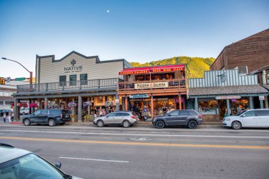 Jackson Hole, WY - 11 Temmuz 2019: Şehir sokakları ve arabaları gün batımında.