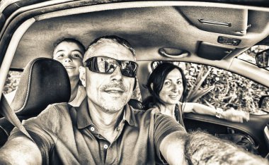 Family relaxing on a car trip taking selfie inside the car