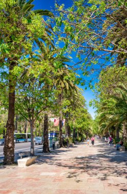 Malaga, İspanya - 14 Nisan 2023: Turistler okyanus kıyısındaki gezintinin tadını çıkarıyor.
