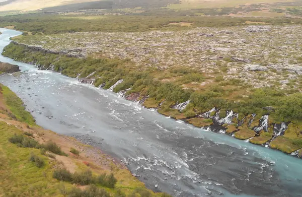 Batı İzlanda 'daki Barnafoss şelalelerinde güzel mavi nehir ve kaya oluşumlarının hava manzarası..