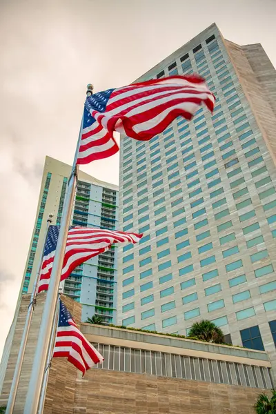 American flags against tall skyscrapers and sky