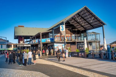 Perth, Avustralya - 31 Ağustos 2023: Turistler gün batımında nehir kenarında yürürler.