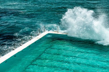 Bondi Sahili, Yeni Güney Galler. Fırtınalı bir sabahta okyanus kenarındaki ünlü havuzlara dalgalar çarpar..