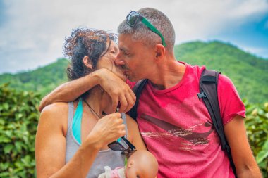 Mutlu çift bir patikada tropik adayı ziyaret ederken öpüşüyor..