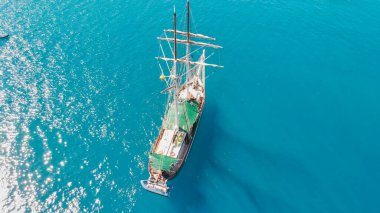 Sailing ship near the shoreline of a beautiful tropical island, aerial view.