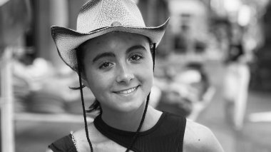 Şehirde hasır şapka takan güzel bir genç kız.