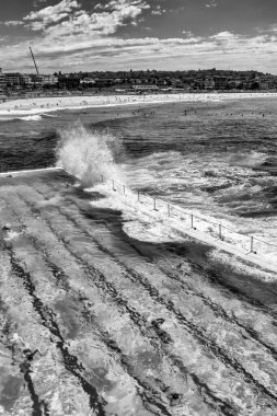 Bondi Sahili, Yeni Güney Galler. Fırtınalı bir sabahta okyanus kenarındaki ünlü havuzlara dalgalar çarpar..