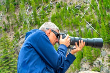 Yellowstone Ulusal Parkı 'nda yakınlaştırma lensli fotoğrafçı.