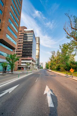 Calgary, Alberta - 22 Temmuz 2024: Calgary şehir merkezinin sokakları ve binaları gün batımında.