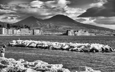 Güzel Mergellina rıhtımı, alacakaranlıkta kayıklar ve fonda çarpıcı bir siluet..