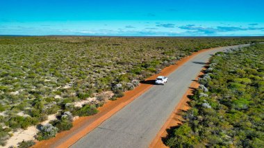 Exploring the wild Australian outback by car, captured from above with stunning detail. clipart