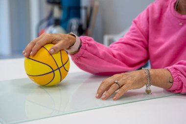 Elle hareket koordinasyonu için top kullanarak fizyoterapi egzersizleri.