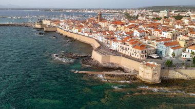 Parlak bir yaz gününde Alghero 'nun sahil şeridini ve tarihi kasabasını gösteren insansız hava aracı görüntüsü..