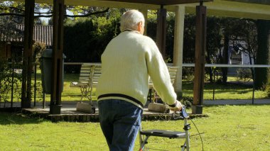 Yaşlı, emekli bir adam ve Walker bahçede geziniyor..