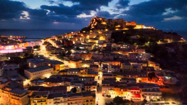 Sardunya 'da parıldayan ışıklar ve sahil cazibesiyle Castelsardo' nun göz kamaştırıcı gece görüntüsü..