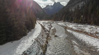 Aerial panoramic view of mountain valley in winter with snow, forest and river. clipart