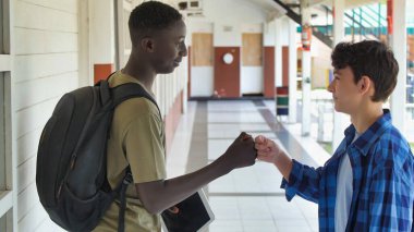 Afrikalı çocuk, beyaz okul arkadaşıyla okul koridorunda buluşuyor..