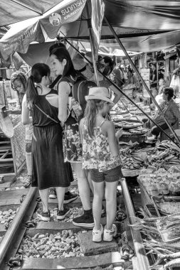 Maeklong, Tayland - 15 Aralık 2019: Trenlerin günlük sokak satıcılarından geçtiği Maeklong Demiryolu 'ndaki eşsiz Tayland pazarı.