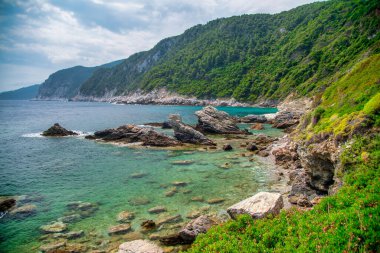 Turkuaz deniz ve yaz aylarında yemyeşil kayalıkların olduğu.
