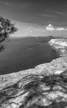 Engebeli dağları ve derin mavi Ege Denizi ile Santorini 'nin çarpıcı kıyı manzarası.
