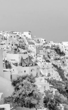 Oia, Santorini 'nin canlı gökyüzü ve klasik Yunan cazibesiyle gün batımında resim gibi manzarası..