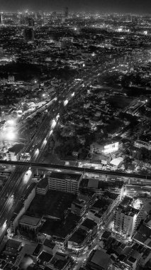 Işıklı gökdelenler ve işlek caddelerle geceleyin Bangkok 'un göz kamaştırıcı hava manzarası.