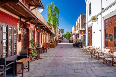 Kos, Yunanistan - 5 Haziran 2014: Geleneksel mimariyle güneşli bir günde Kos caddelerinin cazibesi.