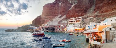 Santorini, Yunanistan - 11 Haziran 2014: Santorini limanı Oia 'nın altında gün batımında altın gökyüzü yansımalarıyla.
