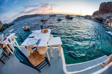 Yunanistan 'ın Santorini kentinde, Ege Denizi' ne tepeden bakan beyaz ve pastel renkli mimarinin çarpıcı kontrastı.