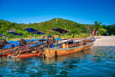 Phi Phi Don, Tayland - 23 Aralık 2019: Nui Beach, Phi Phi Don 'un turkuaz sularındaki uzun kuyruklu teknelerin manzarası.