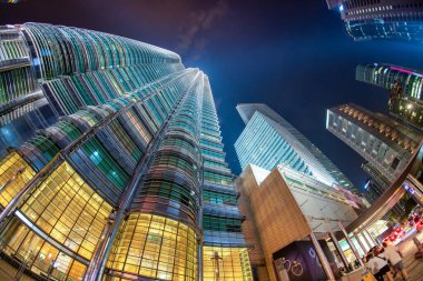 Kuala Lumpur, Malezya - 27 Aralık 2019: Iconic Petronas Kuleleri gece parlıyor, aşağıdaki hareketli sokaklardan yakalandılar.