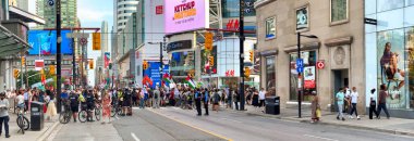 Toronto, Ontario - 1 Ağustos 2024: Filistin yanlısı halk ve polislerle birlikte merkez caddeler boyunca protesto.