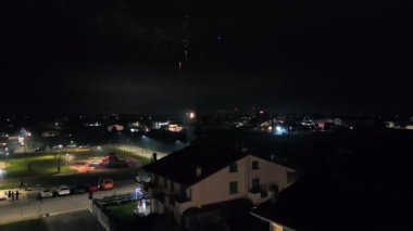 Muhteşem yeni yıl arifesi havai fişekleri şehir parkının üzerindeki gece gökyüzünü aydınlatıyor.