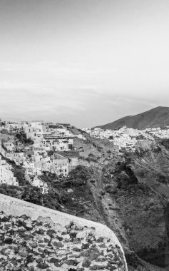 Oia, Santorini 'nin canlı gökyüzü ve klasik Yunan cazibesiyle gün batımında resim gibi manzarası..