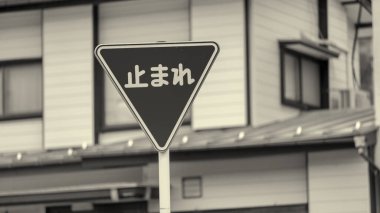 Yerleşim yerlerinde kırmızı dur işareti arkasında tipik bir Japon evi var..