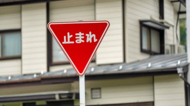 Yerleşim yerlerinde kırmızı dur işareti arkasında tipik bir Japon evi var..