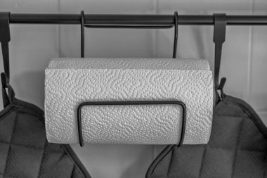 Duvara dayanmış metal bir tutacağa asılı kağıt havlu rulosu..