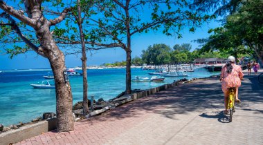 Gili Trawangan, Endonezya - 26 Ağustos 2023: Güneşli bir günde Gili Trawangan 'ın güzel yollarında bisiklet sürmek.