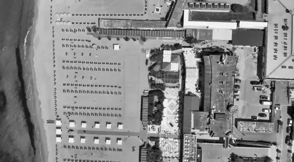 Renkli şemsiyeli ve yaz tatili atmosferli sahil beldesinin insansız hava aracı görüntüsü..