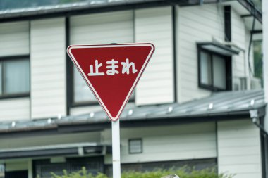 Yerleşim yerlerinde kırmızı dur işareti arkasında tipik bir Japon evi var..