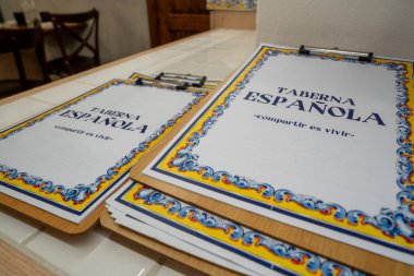 Pisa, İtalya - 12 Mart 2025: Geleneksel İspanyol tavernası içi kırsal ahşap mobilyalar ve sıcak ışıklandırmayla dolu.