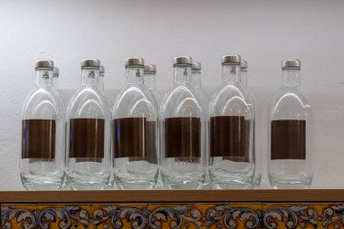Pisa, İtalya - 12 Mart 2025: Geleneksel İspanyol tavernası Raflarda düzgünce yerleştirilmiş şişe su.
