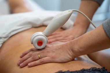 Tedavi amaçlı TECAR masajı rehabilitasyondaki 50 yaşındaki bir kadının sırtına uygulanır..