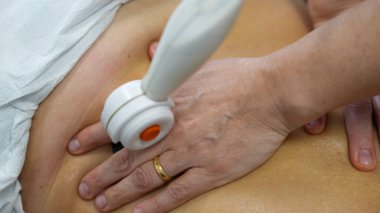 Tedavi için TECAR terapisini kadın hastaların omuzlarında kullanıyor.. 