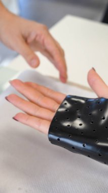 Fizyoterapist rehabilitasyon sırasında genç bir kadına el desteği hazırlar..