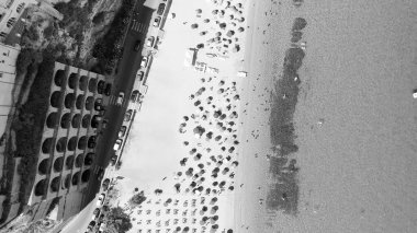 Calabria 'da turkuaz deniz ve güneş şemsiyeli Tropea plajının hava manzarası.