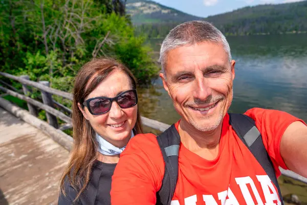 Jasper Ulusal Parkı 'nı keşfeden mutlu çift, nefes kesici dağ manzaralarıyla çevrili..