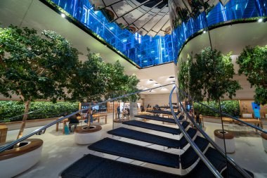 New York City, New York - 14 Haziran 2025: Apple Store 5. Cadde iç mekanı gece aydınlandı teknoloji gösterimleri ve temiz mimari.